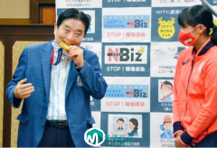 东京奥运会垒球项目冠军的日本选手回乡.市长突然拉下口罩咬住金牌